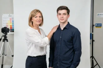 Photographe agréée ANTS installant un client devant un fond blanc pour une photo d'identité officielle en studio